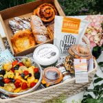pastries and fruit in a hamper with flowers