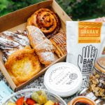 pastries and fruit in a hamper with flowers