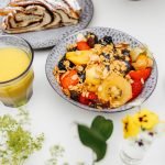 orange juice and bowl of fruit on table